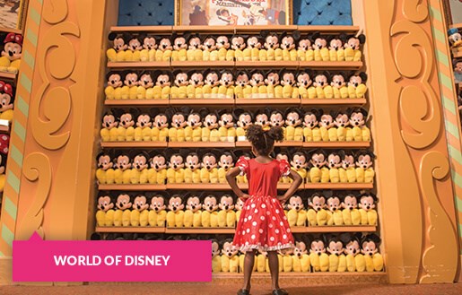 Little girl staring down a wall of Mickey toys at World of Disney